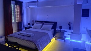 Een moderne slaapkamer met een bed, nachtkastjes en een nachttafel.