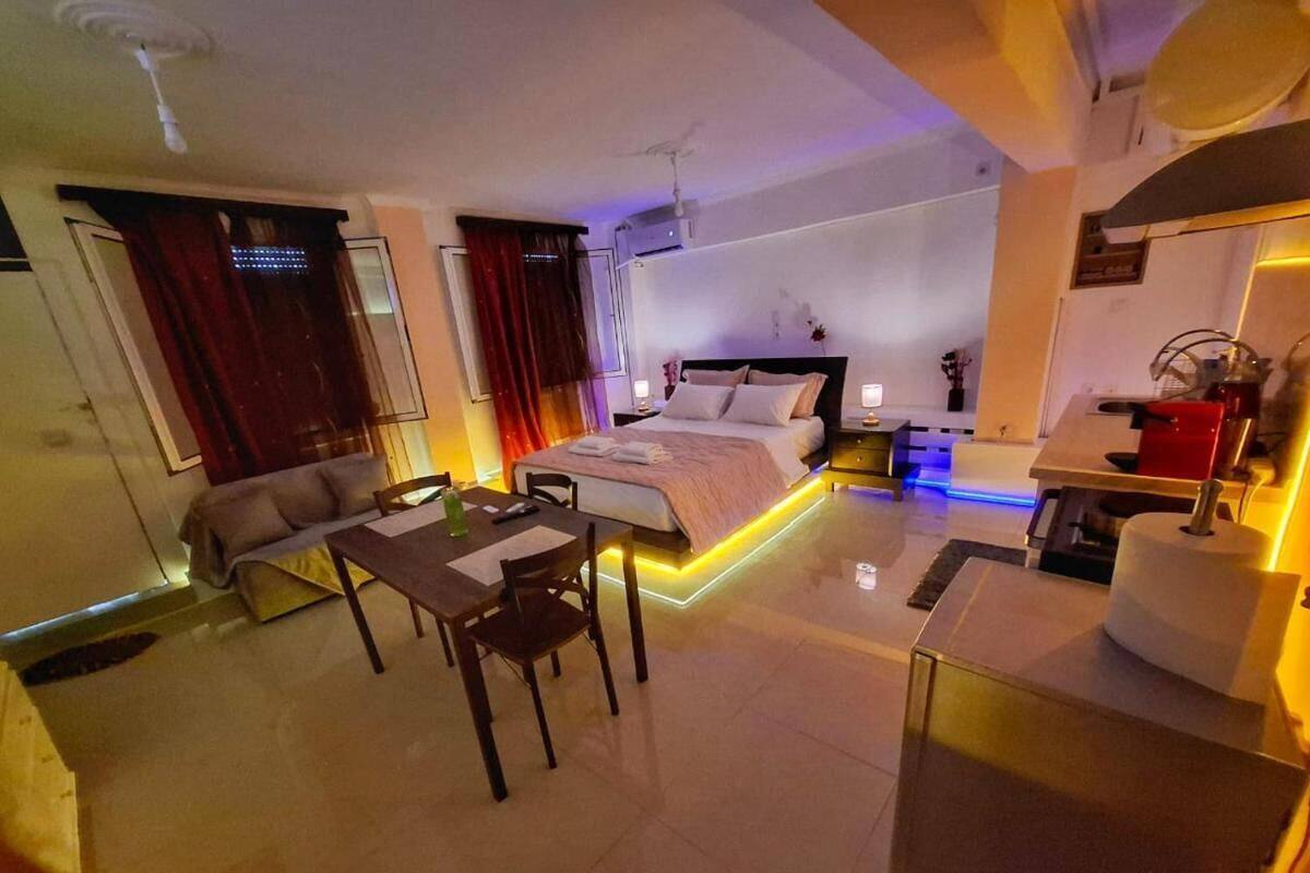 A modern hotel room with a bed, bedside table, and a small dining area.