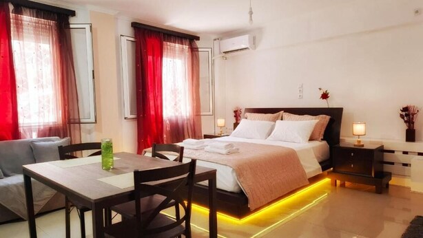 Een moderne hotelkamer met een bed, nachtkastjes, een bureau en stoelen.