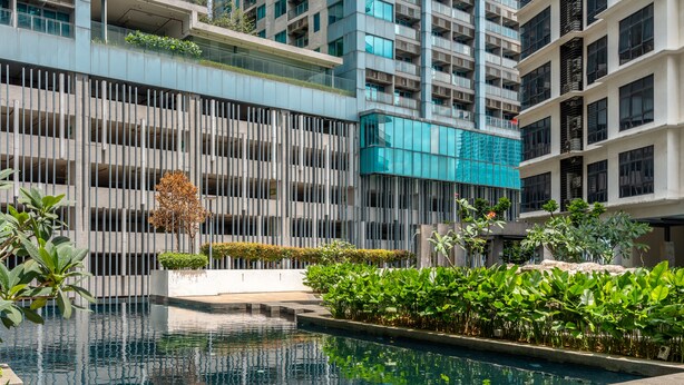 A modern building with a pool and greenery. - Premium 188 Residence (Kuala Lumpur)