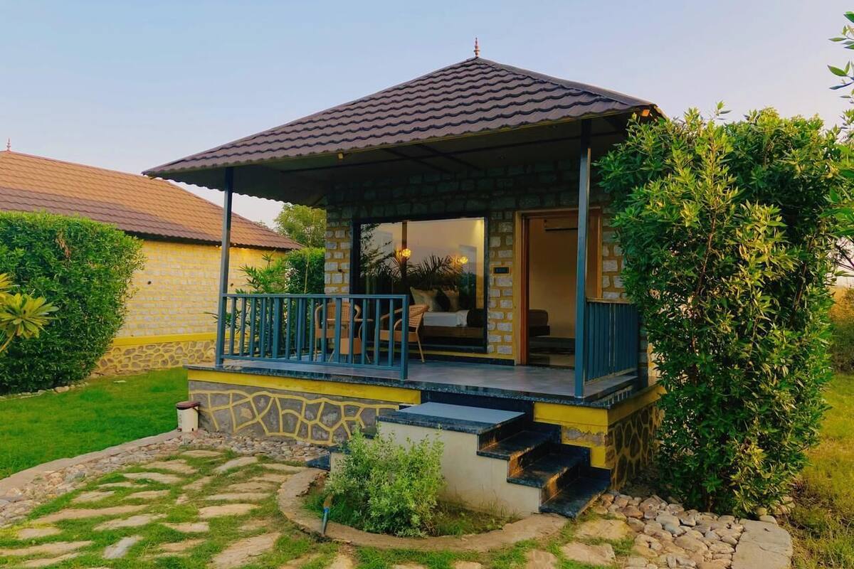 A lodge with a covered porch, stone walls, and a stone pathway leading to the entrance.