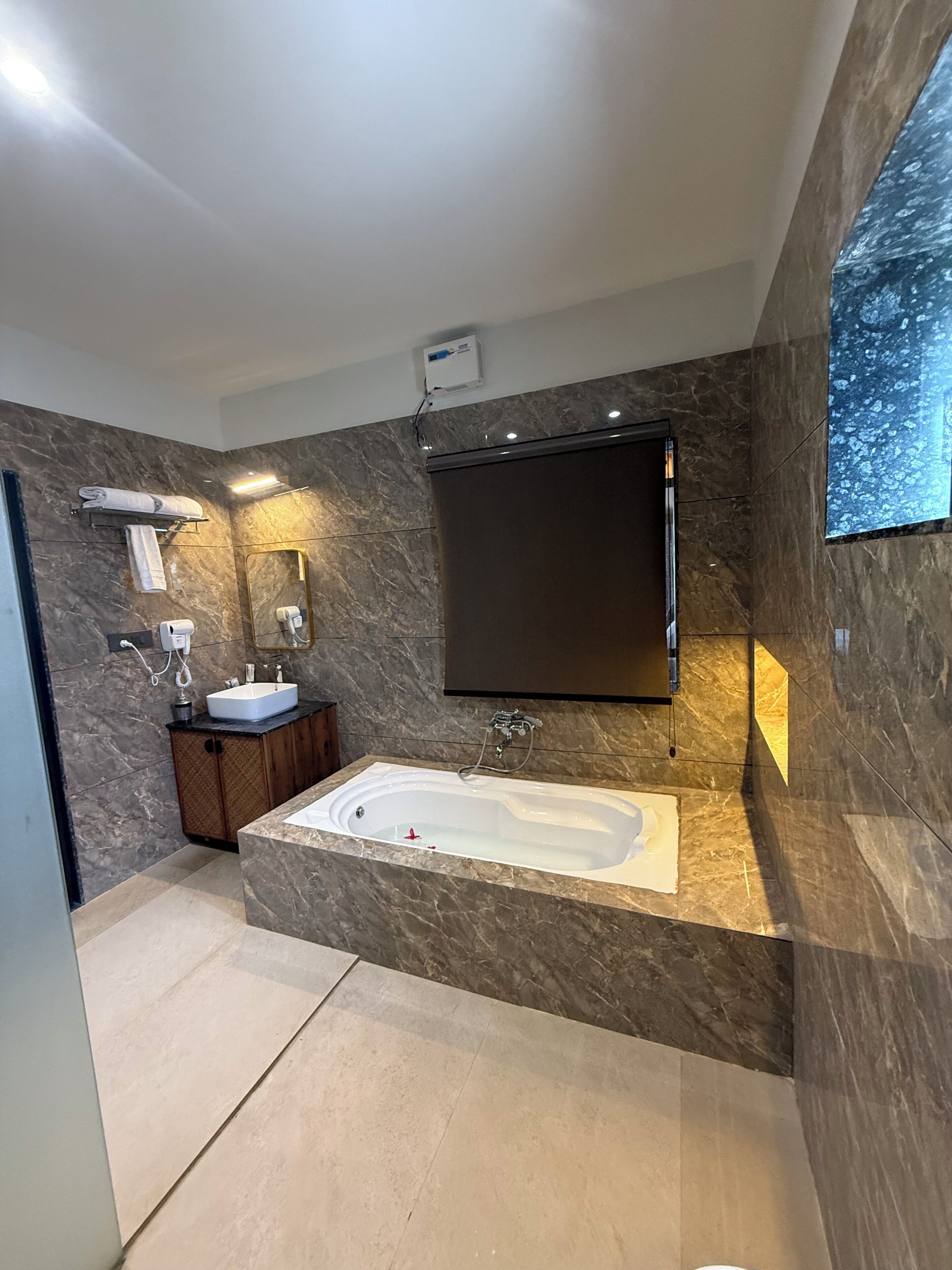 A modern bathroom with a freestanding bathtub, a vanity with a sink, and a large mirror.