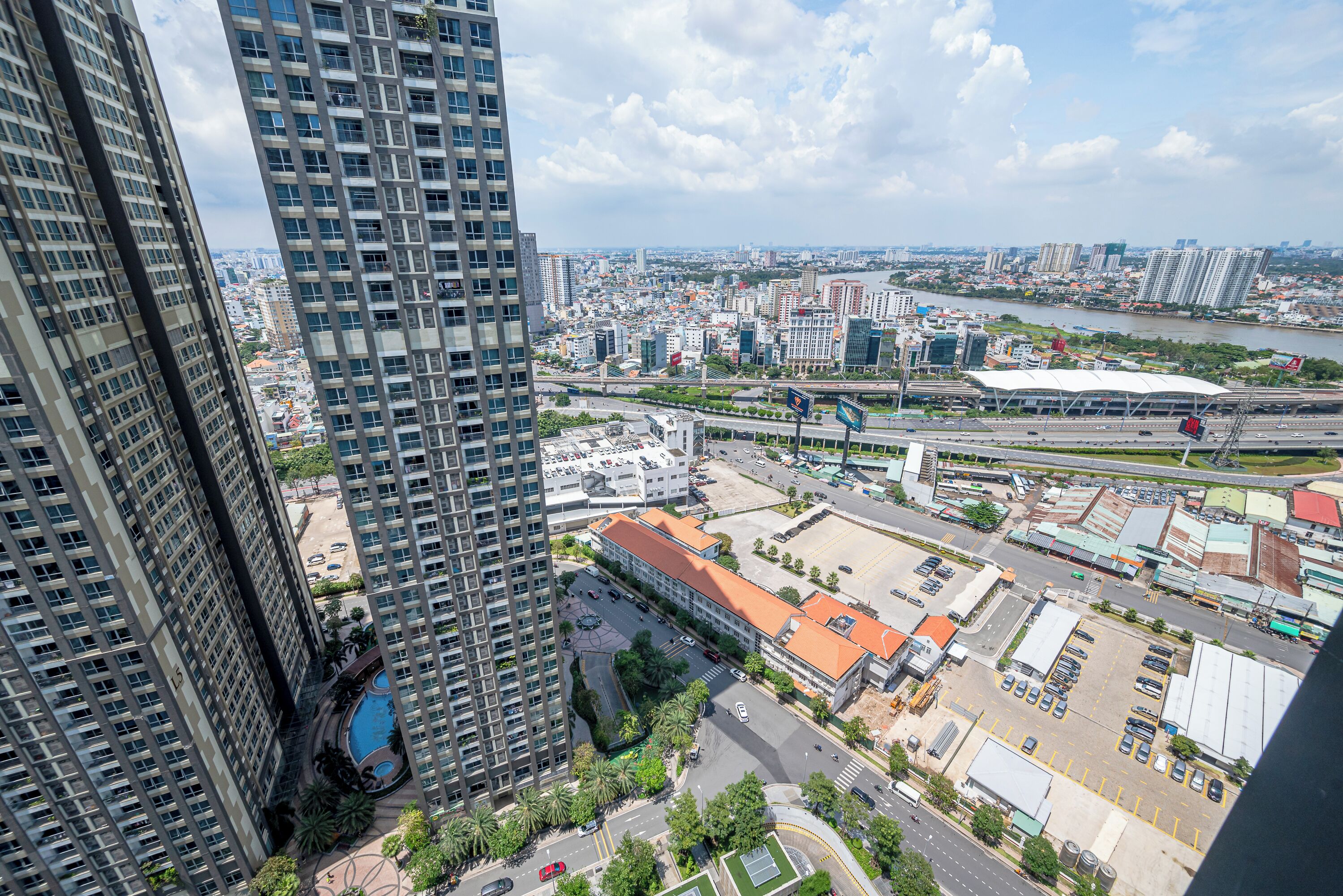 A high-rise building with a swimming pool and a view of a cityscape with a river.