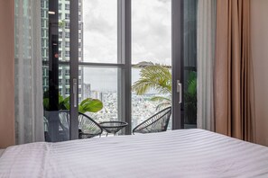 A bedroom with a large window, a bed, and two chairs. - Landmark 81 Luxury Citypoint ANGIA (Ho Chi Minh City)