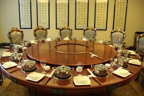 A conference room with a round table, chairs, and a whiteboard. - Yuyang International Hotel (Gaotai)