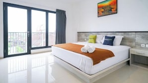 Una habitación de hotel con una cama grande, un cuadro en la pared y un balcón con vistas.