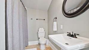 Une salle de bain équipée de toilettes, d’un lavabo et d’un rideau de douche.