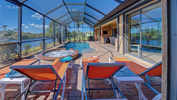 Et overdækket poolområde med liggestole og jacuzzi, med udsigt over et naturskønt landskab.
