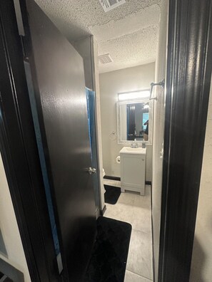 A bathroom with a white sink, mirror, and a towel rack.