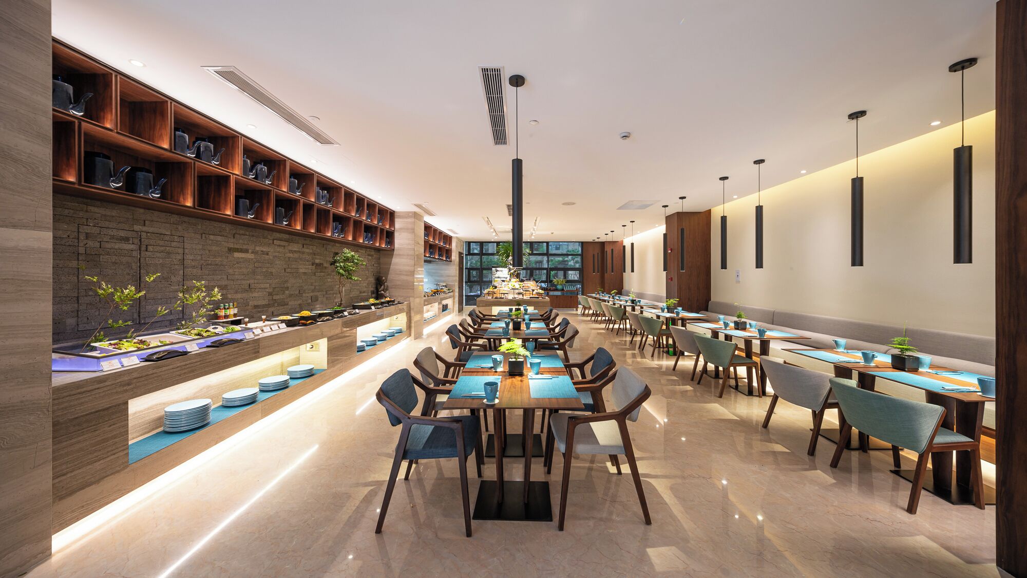 Un restaurante moderno con una barra larga, varias mesas y sillas.