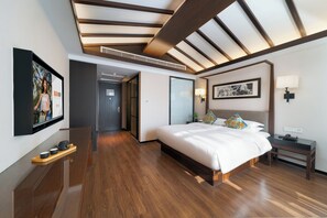 A modern hotel room with a large bed, wooden flooring, a ceiling with exposed beams, a mounted TV, and a bedside table with a lamp. - SSAW Boutique Hotel Shanghai Xuhui (Shanghai)