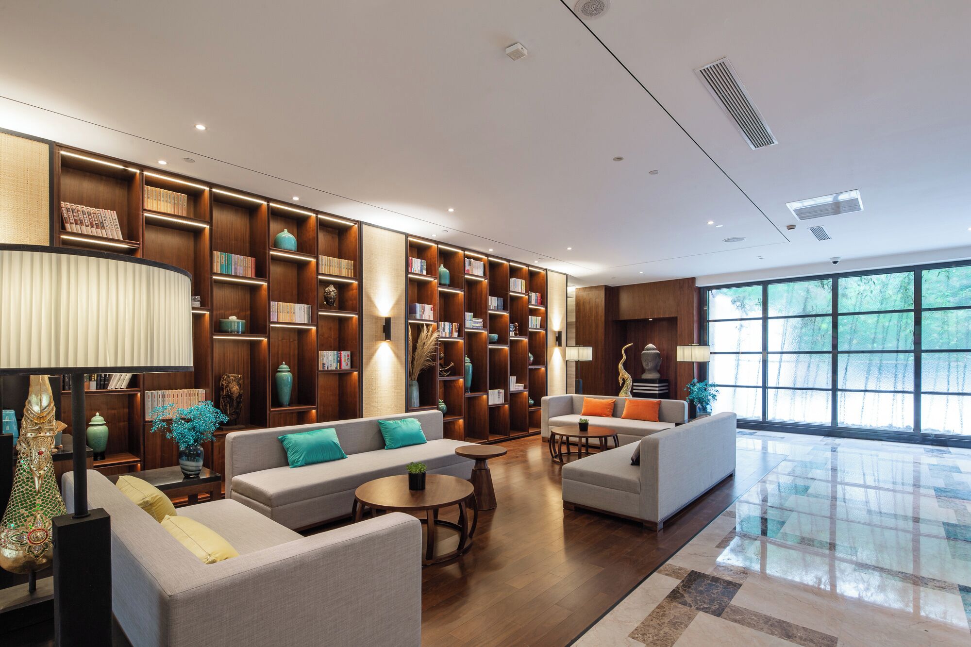 A modern living room with a large bookshelf, sofas, and a coffee table.