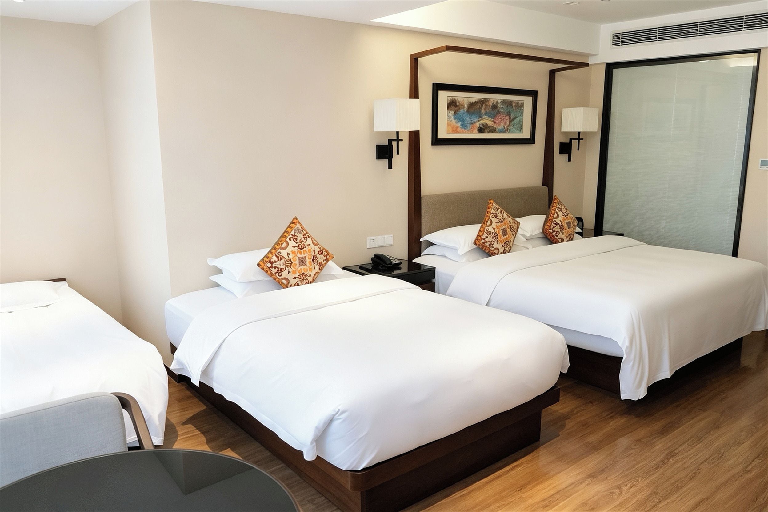 A hotel room with two beds, a desk, and a chair.