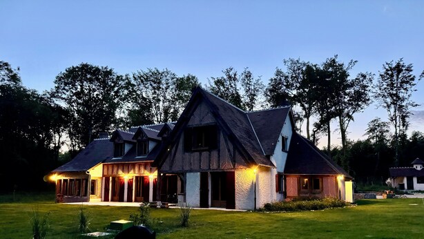 A large, multi-story house with a steeply pitched roof, surrounded by a well-maintained lawn and trees. - Gîte l'orée de Clénord (Mont-près-Chambord)
