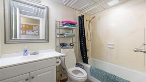 A bathroom with a toilet, sink, and shower. - Charming 2-bedroom apartment in Honolulu with AC, WiFi parking (Honolulu)