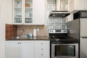 A kitchen with white cabinets, a stainless steel stove, and a microwave. - #StayinMyDistrict Kenton Private Guest House (Portland)