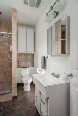A modern bathroom with a shower, toilet, sink, and mirror. - #StayinMyDistrict Kenton Private Guest House (Portland)