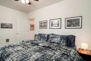 A bedroom with a bed, a nightstand, a lamp, and three framed pictures on the wall. - #StayinMyDistrict Kenton Private Guest House (Portland)