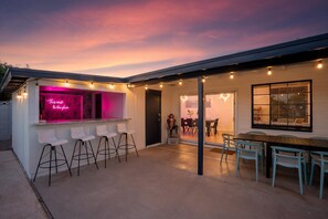 An outdoor patio area with a bar, seating, and a view of the sky. - The Palms Cabana | Pool, Hot Tub, Bocce & PuttPutt (Scottsdale)