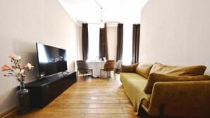 A living room with a TV, sofa, and dining table.