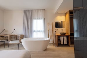 A modern bathroom with a freestanding bathtub, a wooden vanity, and a large mirror.