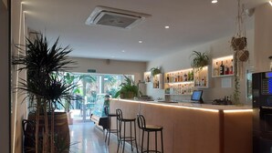 A bar area with a counter, stools, and a variety of bottles. - Play Hotel Ibiza (Ibiza Town)