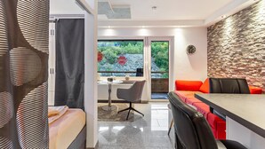 A modern room with a dining area, a small table, and a view of greenery outside. - Apartment 'Gästehaus Centrum 2 Typ 08' with Mountain View, Balcony and Wi-Fi (Willingen (Upland))