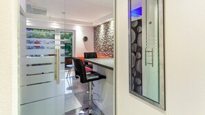 A modern interior with a glass partition, a bar area, and a view of the outdoors. - Apartment 'Gästehaus Centrum 2 Typ 08' with Mountain View, Balcony and Wi-Fi (Willingen (Upland))