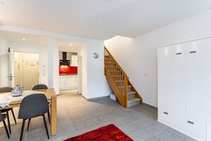 Ein modernes Interieur mit Essbereich, Küche, Treppe und Kleiderschrank.