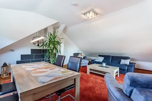 A modern loft with a dining area, a sofa, and a large plant. - Haus Schönblick - "Fewo Sarina 2" with Mountain View, Balcony and Wi-Fi (Willingen (Upland))