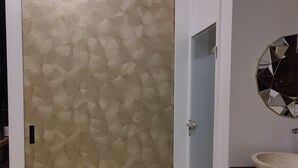 Een kamer met een schuifdeur, een spiegel en een wastafel.