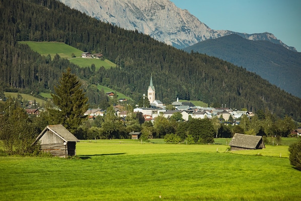 A rural village with a church, a small wooden building, and a mountain backdrop.