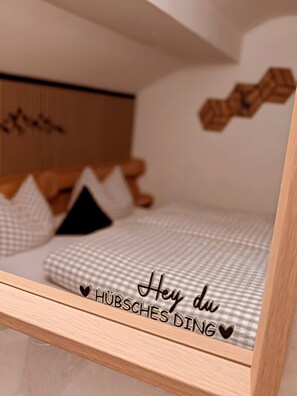 Une chambre à coucher avec un lit, des oreillers, une tête de lit en bois et un élément décoratif fixé au mur.