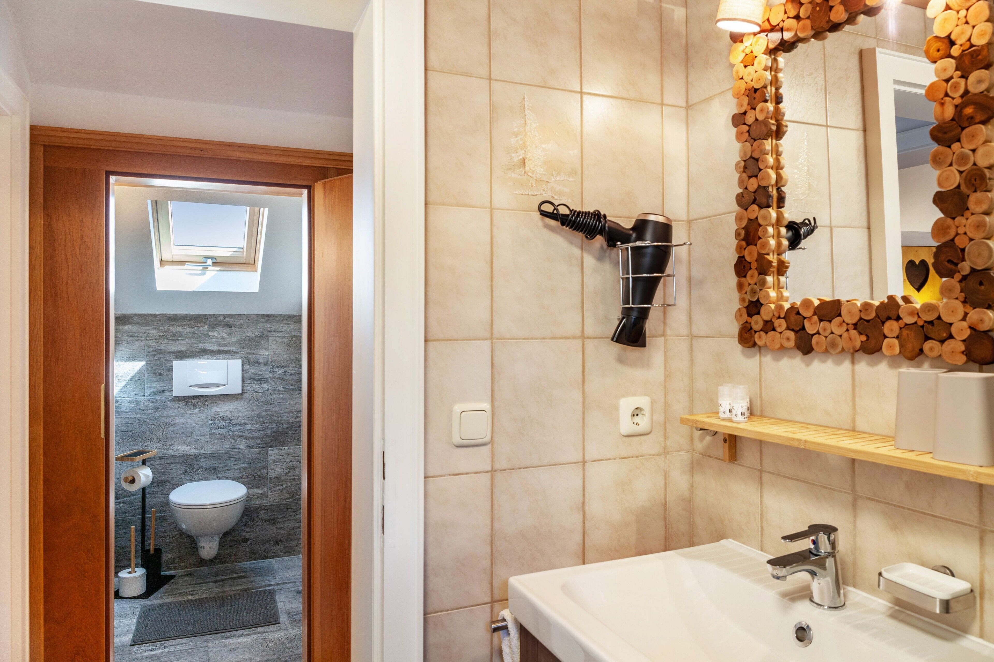 Ein Badezimmer mit Toilette, Waschbecken und Spiegel.
