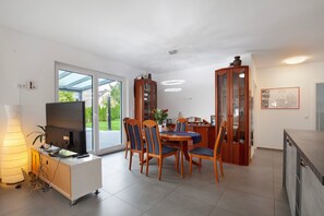 A modern kitchen with a dining area, large windows, and a built-in TV. - Apartment 'Großzügige Wohnung' with Shared Pool, Private Terrace and Wi-Fi (Brechen)