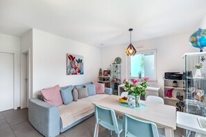 A modern living room with a sofa, dining table, chairs, and a globe on a shelf. - Apartment 'Ruhige Wohnung' with Shared Pool, Private Terrace and Wi-Fi (Brechen)