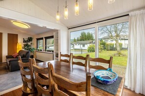 Un coin repas avec une table en bois, des chaises et un bol décoratif bleu.