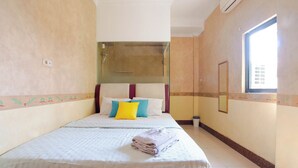 Ein Hotelzimmer mit Bett, Fenster und Duschbereich.