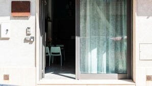 A sliding glass door with a newspaper curtain, a small plaque above it, and a number '13' on the wall to the right.