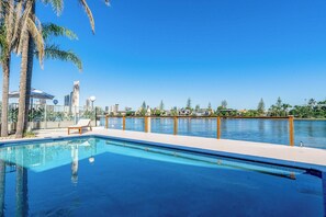 Piscina con vista a un horizonte urbano y palmeras.