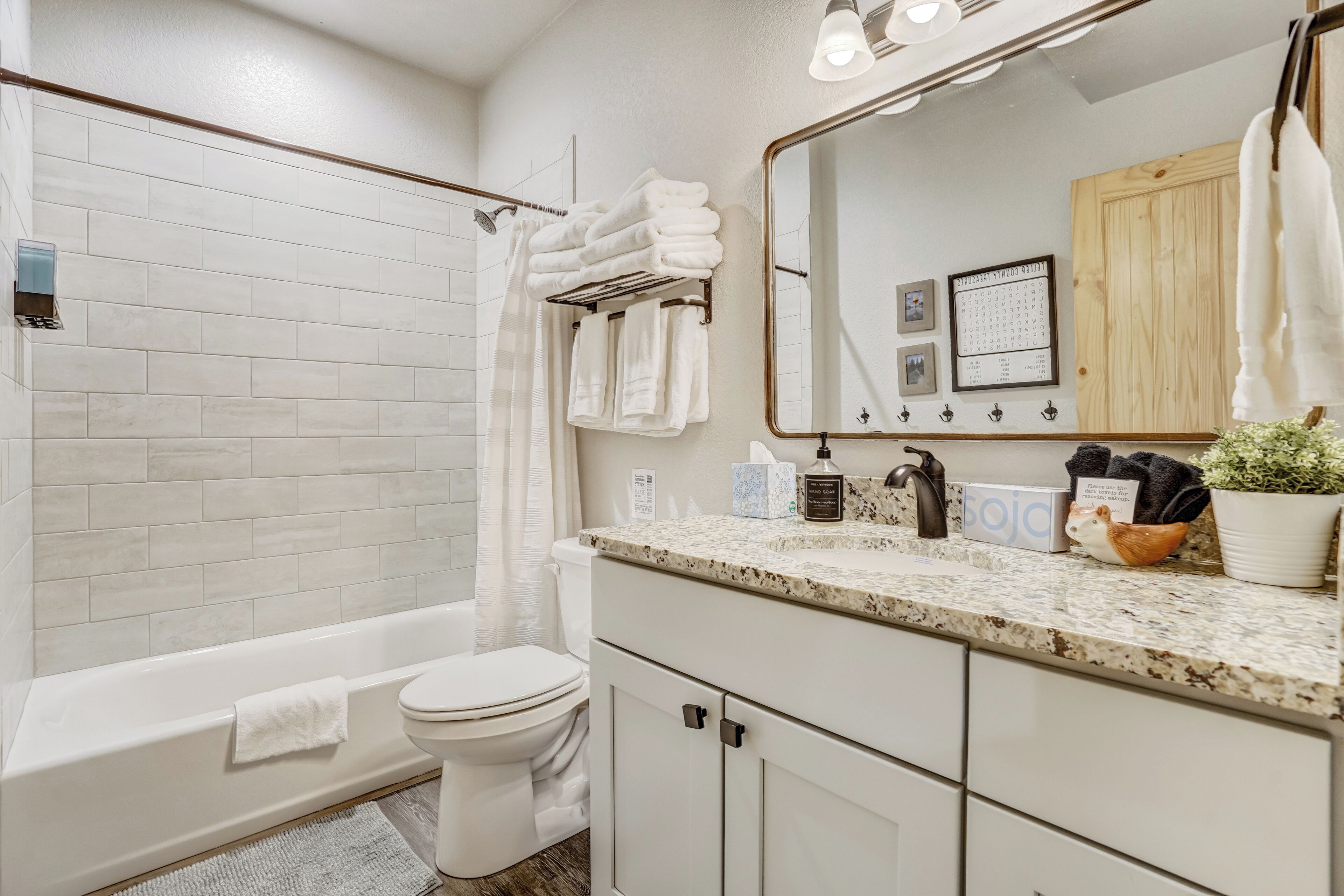 Une salle de bain moderne avec une baignoire blanche, des toilettes et un espace lavabo.