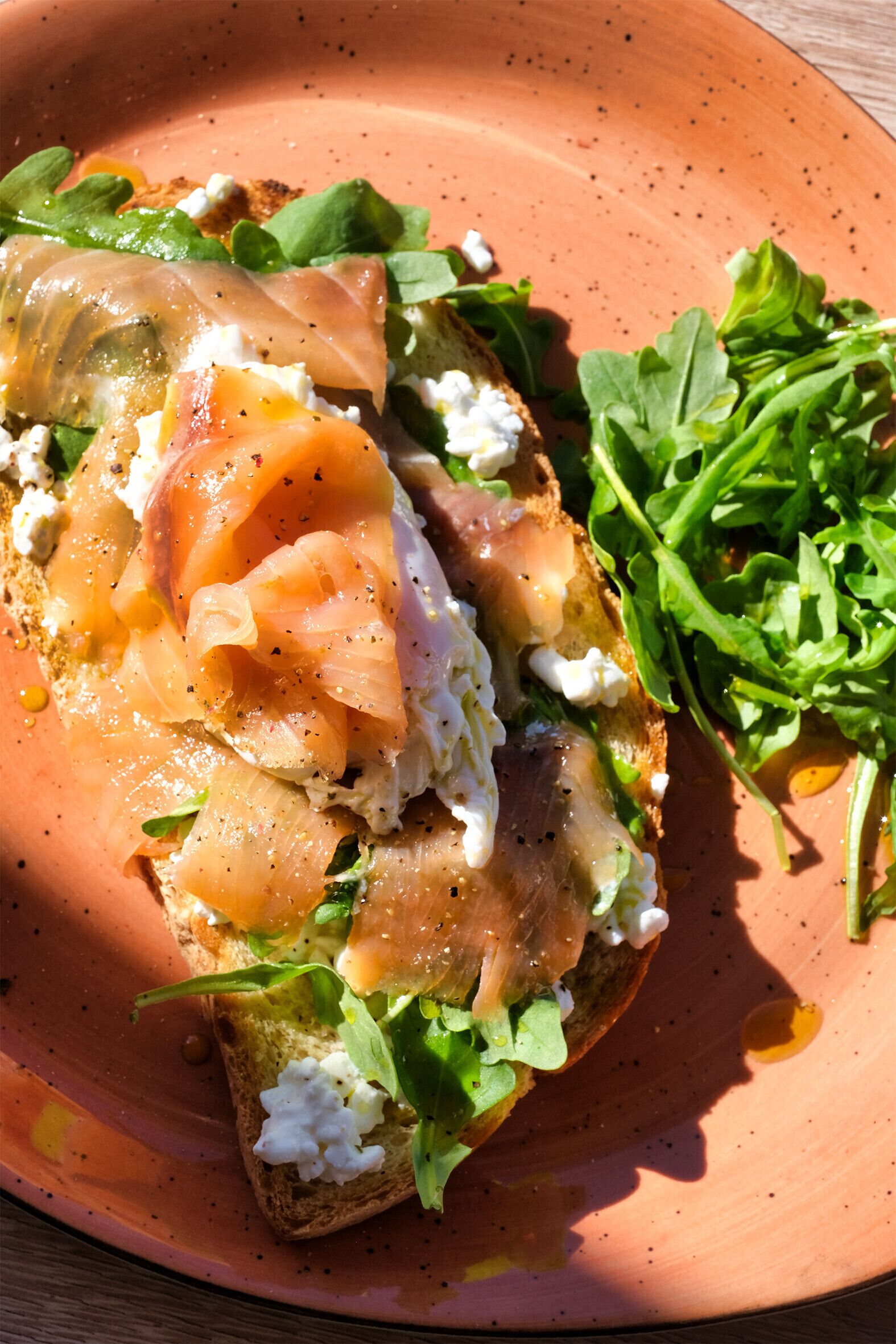 Un plato con sándwich, vegetales verdes y queso.