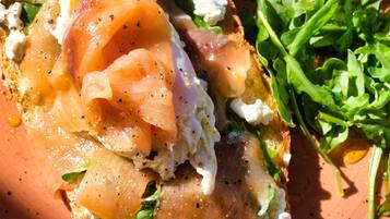 Un plato con sándwich, vegetales verdes y queso.