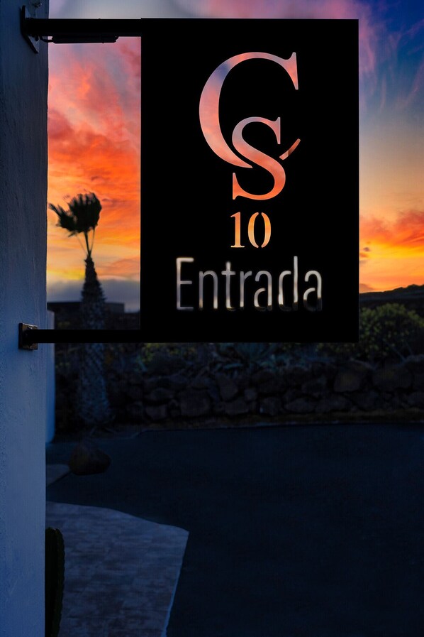 A sign with the number 10 and the word "Entrada" against a sunset background.