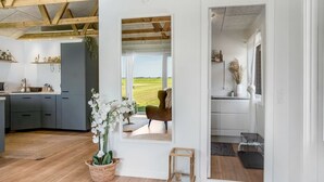 A modern kitchen with wooden beams, a large window, and a view of the outdoors. - "Kanerva" - 100m to the fjord by Interhome (Storvorde)