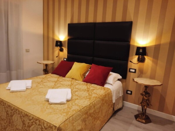 A hotel room with a large bed, two bedside tables, and a headboard with built-in lighting. - MARITZA GUEST HOUSE 1 (Rome)