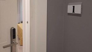 Una puerta con teclado numérico y un letrero que indica el número de habitación 1.