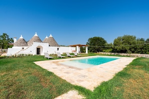 A villa with a swimming pool, white walls, and conical roofs. - 4152 Trulli Salsapariglia by Perle di Puglia (Putignano)