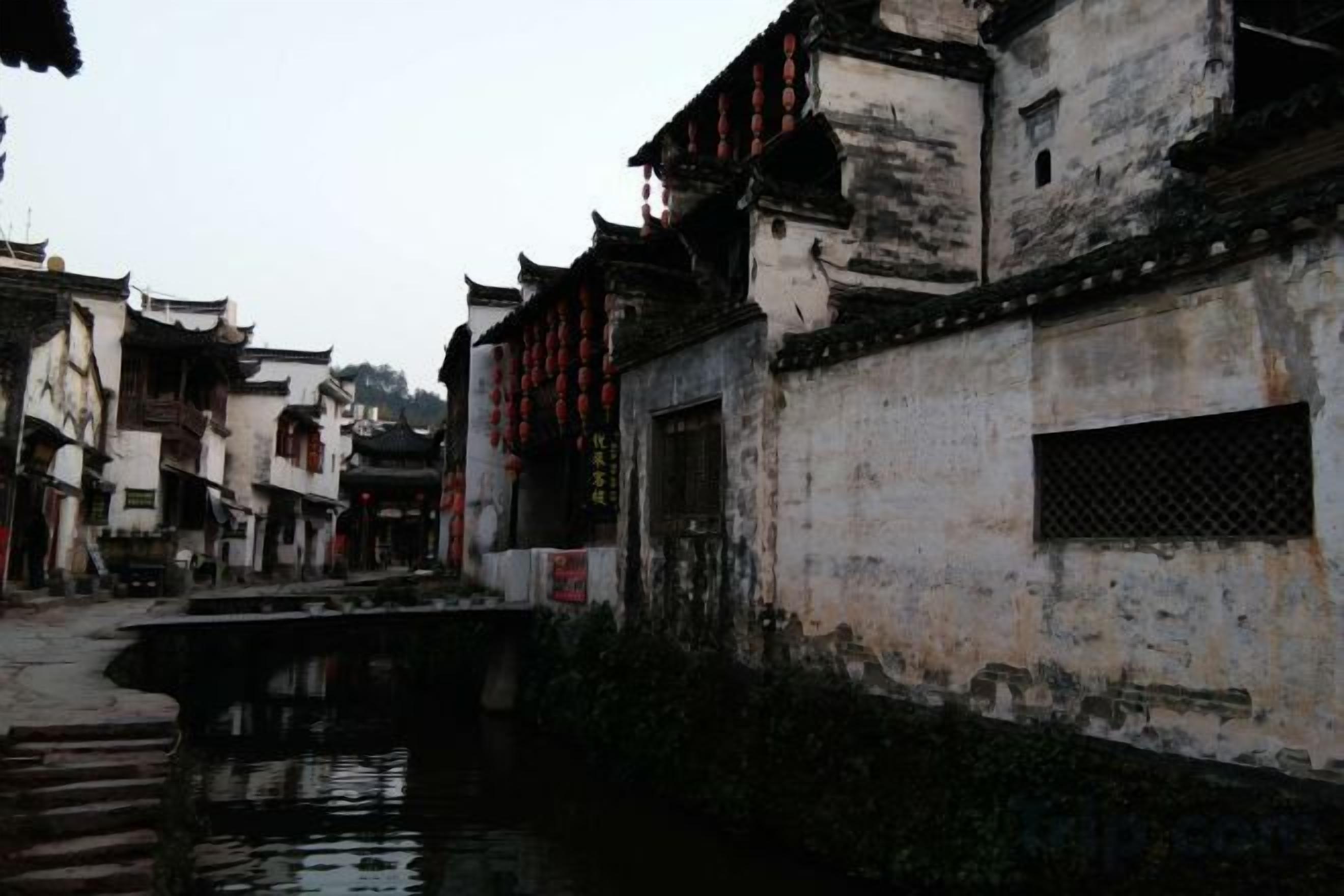 Un edificio tradizionale affacciato su un canale, con un ponte e uno stile architettonico tipico.
