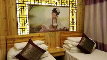Una habitación con paredes de madera, una pintura tradicional china y dos camas con almohadares estampados.